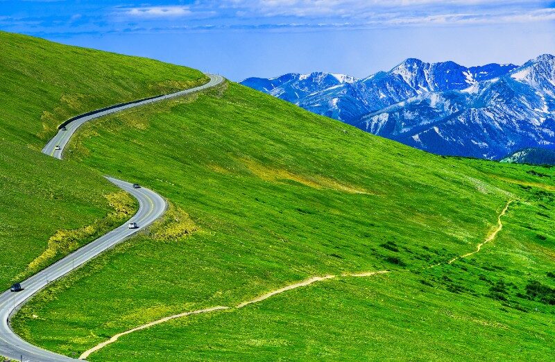 Road going thru green grassy field